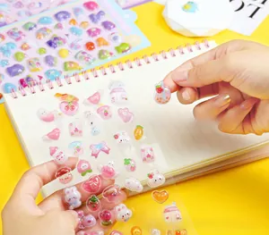 Close-up of 3D cartoon resin stickers on a notebook with cute rabbit and strawberry designs