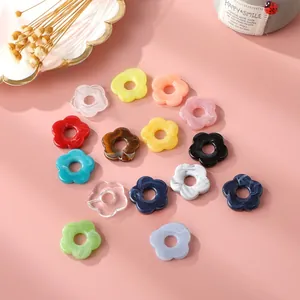 Flat lay of colorful acrylic flower pendants with center holes for DIY jewelry making