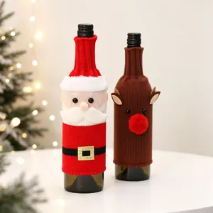 Detail of knitted Santa and reindeer wine bottle covers in cozy Christmas setting