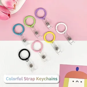 Set of 7 colorful strap keychains with metal rings and transparent PVC bands on pastel background