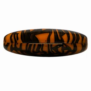 Detail of elegant amber resin clutch bag with tortoiseshell pattern and gold metal hinge