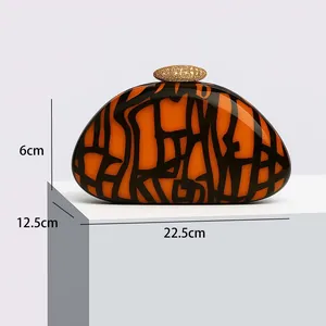Detail view of orange acrylic evening clutch showing 22.5cm width and golden stone clasp