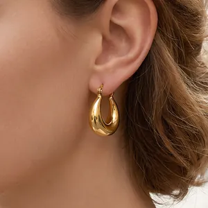 Detailed view of bold chunky golden teardrop hoop earrings with high-polish finish