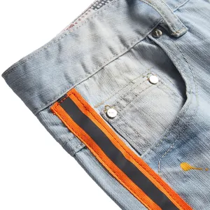 Jeans dritti azzurri con fettuccia neon, schizzi di vernice e rivetti in metallo