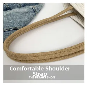 Detail of reinforced light brown woven shoulder straps on a striped cotton tote bag