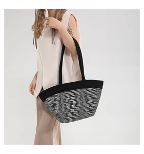 Detail of hand-woven striped tote bag showing durable black straps and knit texture