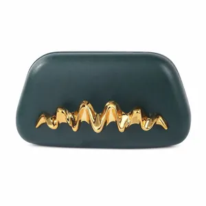 Détail de la pochette en cuir PU vert émeraude avec garniture métallique dorée ondulée