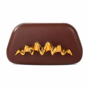 Détail de la pochette en cuir marron foncé avec ferrure métallique dorée ondulée