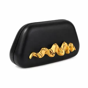 Détail de la pochette en PU noir avec accessoire métallique ondulé doré pour soirée chic