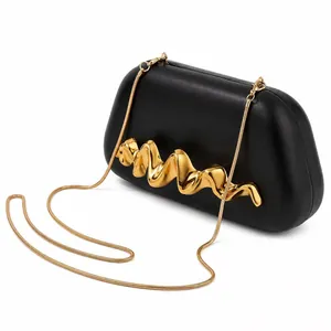 Vue détaillée de la pochette noire en PU mat avec garniture dorée ondulée et chaîne