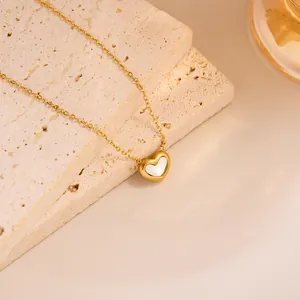 Close-up of heart-shaped pendant necklace with white mother-of-pearl inlay on gold chain