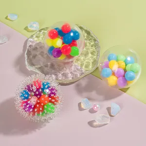 Macro shot of transparent stress relief balls filled with colorful beads on a glass tray
