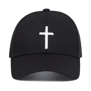 Detailed close-up of white cross embroidery on a premium black cotton baseball cap