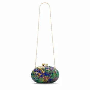 Detail of artistic mosaic texture and golden metal clasp on shell evening clutch bag