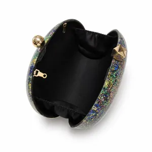 Detail of glitter evening clutch showing black satin lining and gold chain attachments