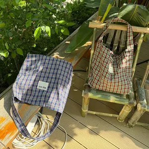 Detail view of large checkered canvas hobo tote bags in blue and brown color patterns