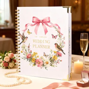 Detalle del planificador de bodas completo con encuadernación en espiral dorada y flores
