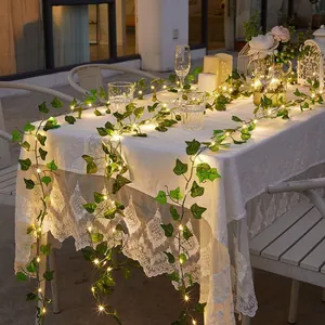 Close-up of warm LED solar ivy string lights decorating an outdoor garden dining table