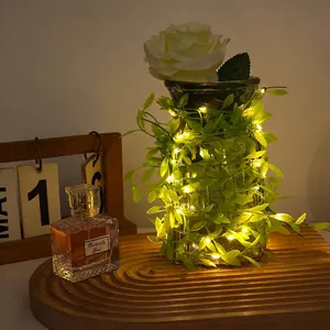 Solar artificial green ivy vine string lights with warm LED bulbs in a glass vase