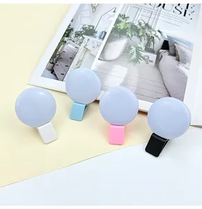 Mini round LED selfie ring lights in white, blue, pink and black with clip-on base