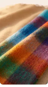 Macro detail of soft brushed plaid scarf featuring warm mohair texture and vibrant colors