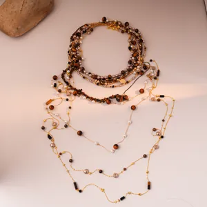 Layered golden tiger eye stone necklace with pearls and bohemian style beads on beige base