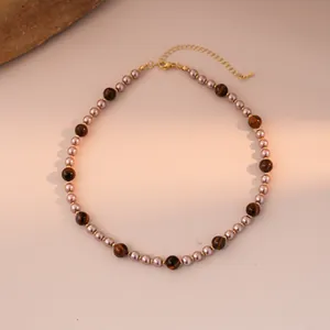 Detail of round tiger eye stone and pink pearl beaded necklace with gold lobster clasp