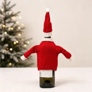 Detail of red knit Christmas wine bottle cover with mini Santa hat and fuzzy white trim