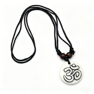 Detail of Hindu Om resin pendant with wood beads and black woven cord on white background