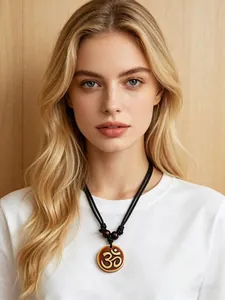 Close-up of Om resin pendant with gold symbol and black braided rope for meditation