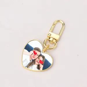 Detail of heart-shaped gold metal keychain with custom photo insert and lobster clasp