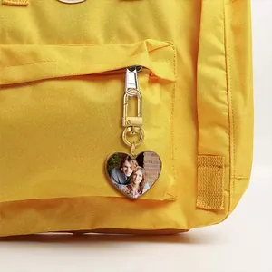 Detailed view of a gold heart sublimation keychain with custom photo on a yellow backpack