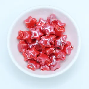 Top view of glossy red star-shaped ceramic beads for DIY jewelry making in a white bowl