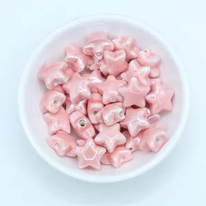 Macro shot of light pink star-shaped ceramic beads for DIY necklace making in a white bowl