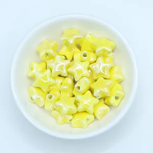 Close-up of glossy yellow star-shaped ceramic beads for handmade jewelry making