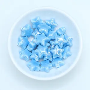 Macro view of light blue glazed star-shaped ceramic beads for DIY jewelry making