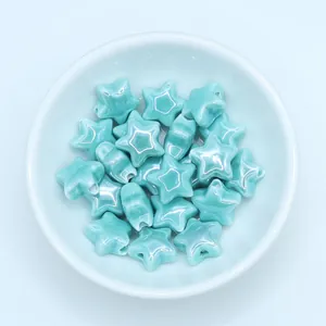 Macro shot of glazed mint green star-shaped ceramic beads for DIY jewelry making