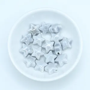 Macro view of blue star-shaped glazed ceramic beads with pre-drilled holes for DIY jewelry