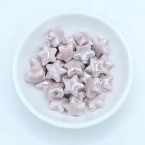 Macro shot of glazed lavender star-shaped ceramic beads in a white bowl for DIY jewelry