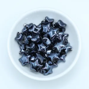 Macro view of metallic blue ceramic star beads for DIY jewelry making in a white bowl