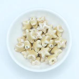 Macro detail of star-shaped ceramic beads with glossy cream glaze for DIY jewelry making