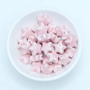 Macro shot of light pink star ceramic beads for handmade jewelry DIY in a white bowl