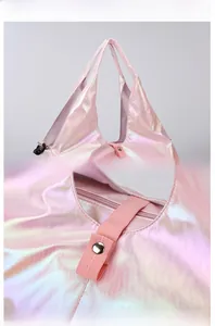 Macro detail of holographic travel bag handle, silver hardware and pink metallic fabric