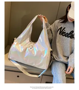 Close-up of holographic silver laser travel bag with wide shoulder strap and pearl luster texture