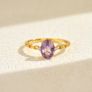 Detailed macro view of 18K gold ring with oval purple gemstone and chain band design