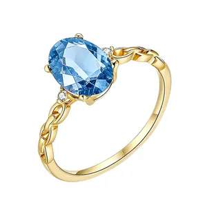 925 silver interlocking ring with 18K gold plating and oval blue gemstone center