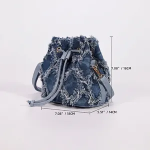 Tie-dye denim bucket bag with distressed fringe texture and adjustable shoulder strap