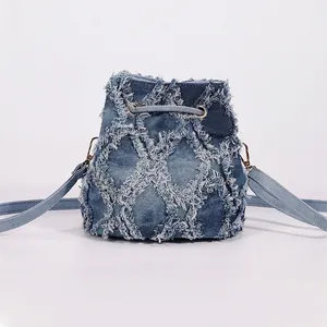 Tie-dye denim bucket bag featuring quilted diamond pattern with fringe and drawstring