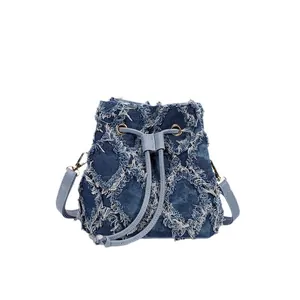 Deep blue tie-dye denim bucket bag featuring distressed fringe diamond lattice patterns