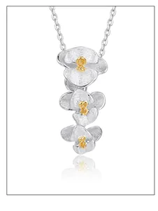 Detailed view of silver orchid pendant with hand-brushed petals and yellow center beads